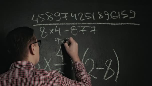 Homem escreve fórmula matemática no quadro negro — Vídeo de Stock