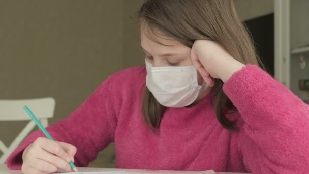 Ragazza in maschera medica studiare a casa durante la pandemia di coronavirus — Video Stock