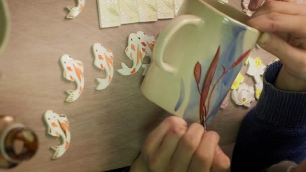 Vrouwelijke keramist schildert een klei product.. Verticale video — Stockvideo