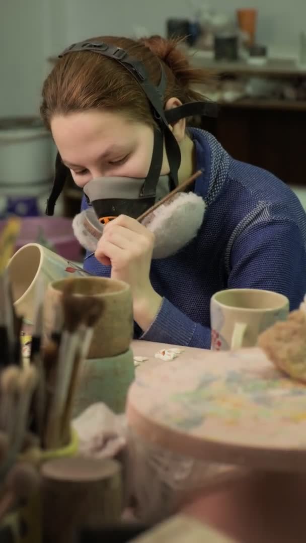 Female ceramist paints a clay product.. Vertical video — Stock Video