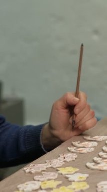 Kadın seramik kil bir ürünü dikey bir videoya boyuyor.