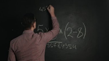 Adam tahtaya matematik formülü yazıyor.