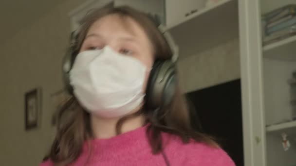 Ragazza in maschera medica studiare a casa durante la pandemia di coronavirus — Video Stock