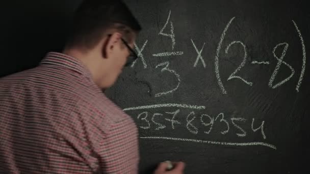 Hombre escribe fórmula matemática en pizarra — Vídeos de Stock