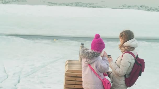 Familie picknick op een bevroren rivier. — Stockvideo