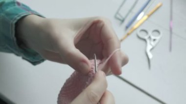 Genç bir kadın örgü örüyor..