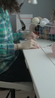 Genç bir kadın örgü örüyor. Dikey video