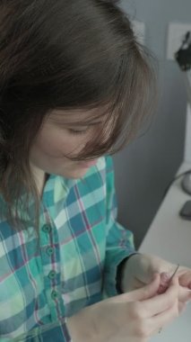 Genç bir kadın örgü örüyor. Dikey video