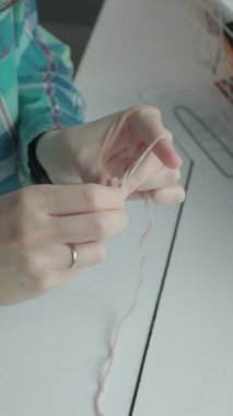 Genç bir kadın örgü örüyor. Dikey video