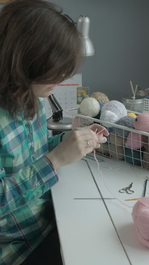 A young woman crochets. Vertical video — Stock Video