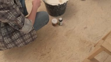 Kadın ev ressamları odadaki duvarları boyuyor..