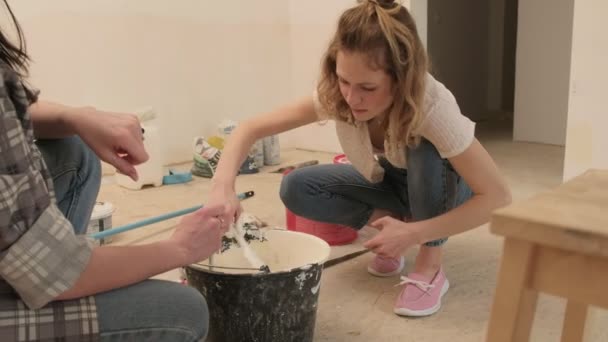 Pintores femininos pintam as paredes da sala . — Vídeo de Stock