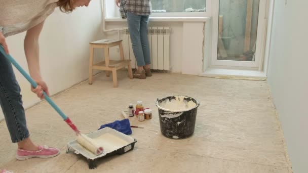 Kadın ev ressamları odadaki duvarları boyuyor.. — Stok video