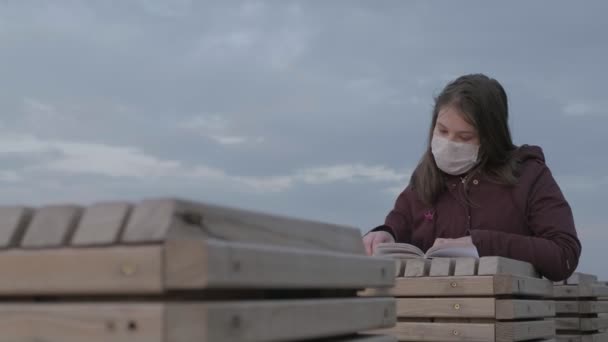 Fiatal lány fekete maszkban egyedül a szabadban. Coronavirus pandémia — Stock videók