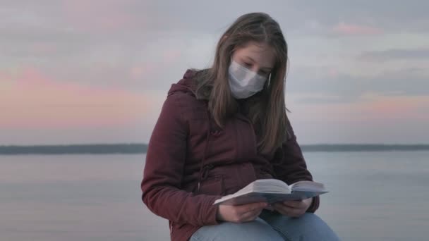 Young girl in black mask alone outdoors. Coronavirus pandemic — Stock Video