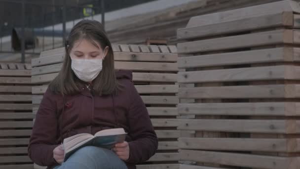 Chica joven con máscara negra solo al aire libre. pandemia de Coronavirus — Vídeo de stock