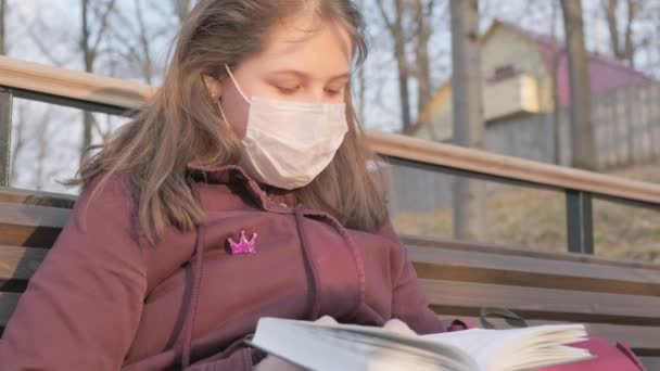 一个戴着黑色面具的小女孩一个人在外面.Coronavirus大流行病 — 图库视频影像