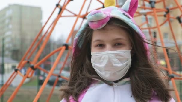 เด็กสาวในหน้ากากป้องกันที่สนามเด็กเล่น . — วีดีโอสต็อก