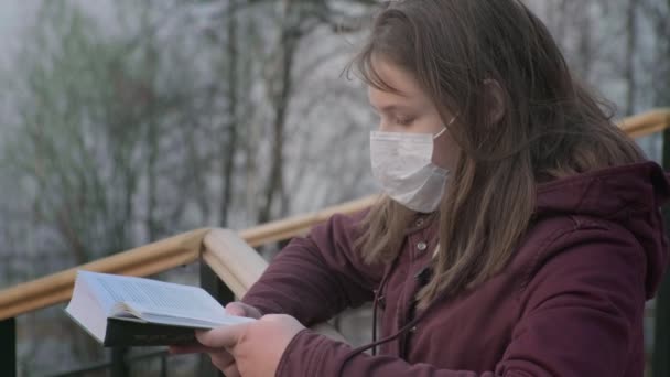 Giovane ragazza in maschera nera da sola all'aperto. Pandemia di coronavirus — Video Stock