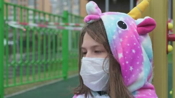 놀이터에서 보호용 마스크를 쓴 어린 소녀. — 비디오