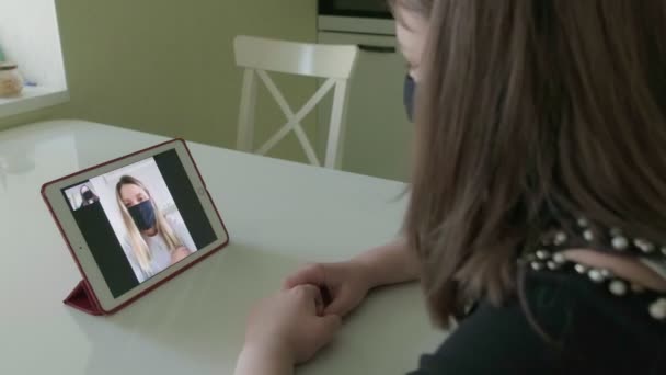 Twee jonge vrouwen praten via videolink in medische maskers — Stockvideo