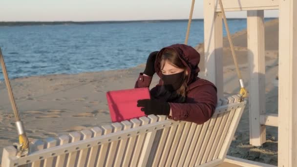 Dışarıdaki maskeli kız tablet kullanıyor. izolasyon — Stok video