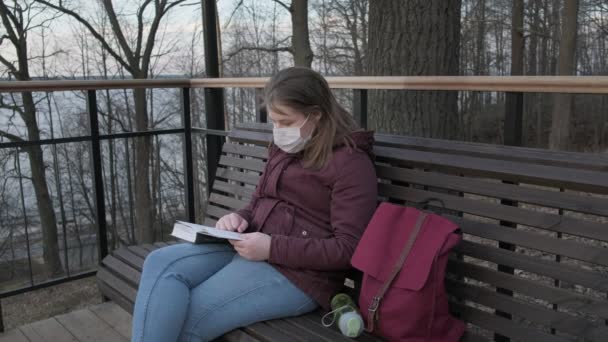 Chica joven con máscara negra solo al aire libre. pandemia de Coronavirus — Vídeos de Stock