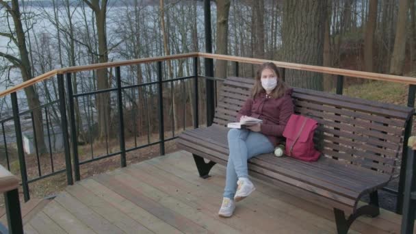 Chica joven con máscara negra solo al aire libre. pandemia de Coronavirus — Vídeos de Stock