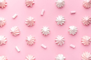 Pembe kağıttan arka planda pembe ve beyaz krema kompozisyonu. Pastel. Üst görünüm