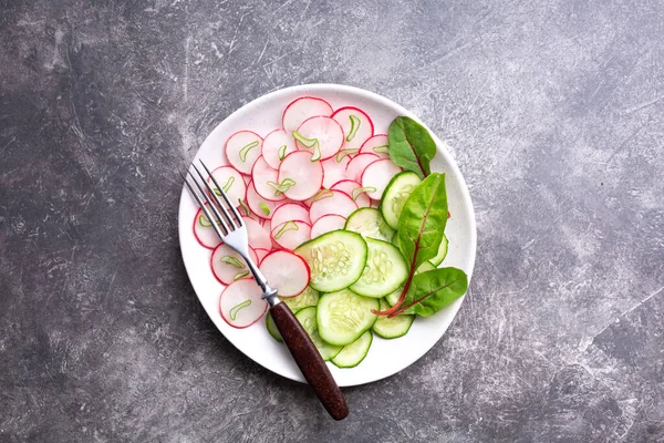 Gri arka planda salatalıklı hafif turp salatası. Sağlıklı beslenme konsepti. Üst görünüm, alanı kopyala