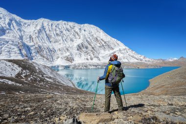 Trekker turist sopa ve sırt çantası Tilicho Gölü ile. 