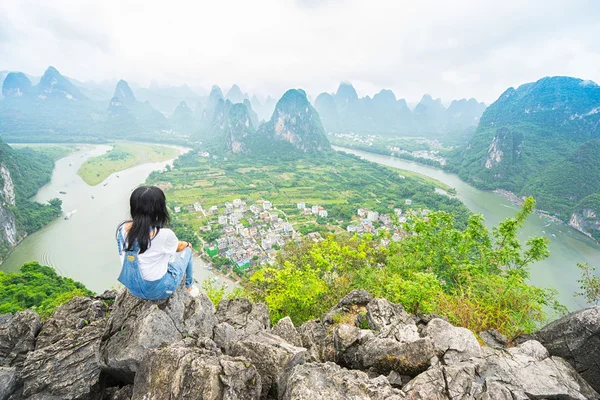Женщина сидит на вершине горы — стоковое фото