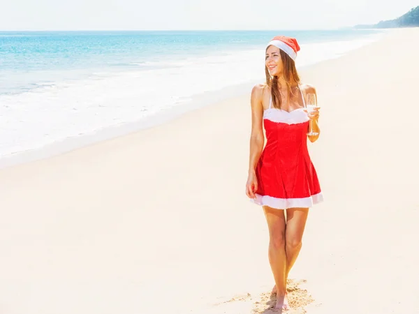 Mulher em roupas de Natal vermelho na praia do mar — Fotografia de Stock