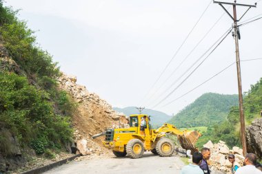 Excavator cleans road in Nepal  clipart