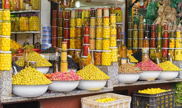 Puesto de mercado que vende aceitunas frescas y alimentos embotellados — Foto de Stock
