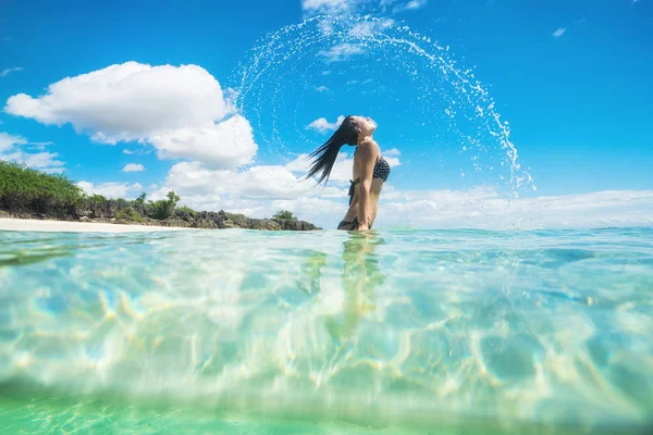 Mujer en traje de baño salpicando agua con su pelo — Foto de Stock