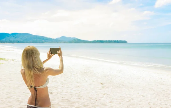 Turista tomando fotos de la hermosa playa — Foto de Stock