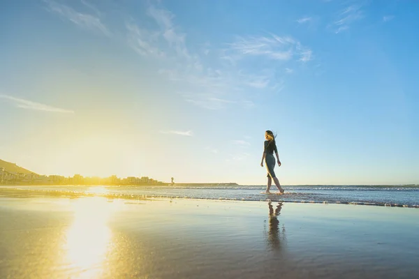 Kobieta w sukni spacer na plaży — Zdjęcie stockowe