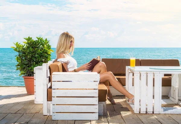 Wanita membaca buku di kafe pantai — Stok Foto