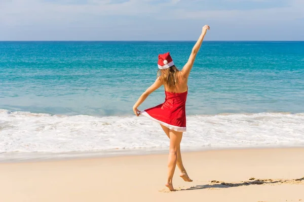 熱帯のビーチにミセス クロース コスチュームで幸せな女 — ストック写真