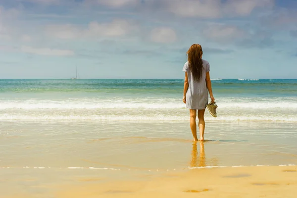 Frau in Kleid steht am Strand — Stockfoto