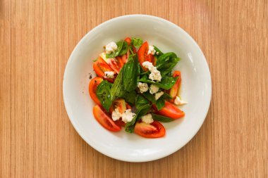 Salata yaprakları, domates ve peynir ile. Havai görünümü. Seçici odak.