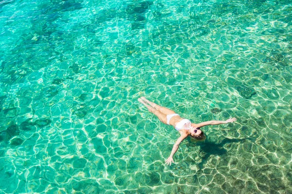 Woman in white bikini swimming in  beautiful blue sea. Overhead view. Aerial shot.