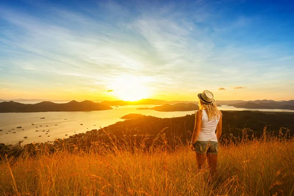 山の頂上からの夕日を楽しむ女性 島と背景の空 背面図 — ストック写真