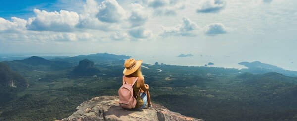 Молодая женщина с рюкзаком наслаждается захватывающим видом на пейзаж с вершины горы. Путешествия Comcept. Вид сзади. Баннерное издание
.