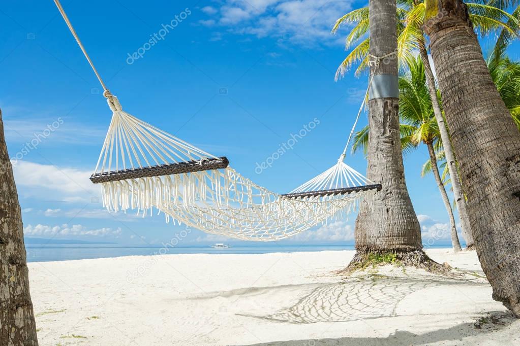 Hammock between palms on the beautiful tropical beach. 