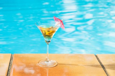 Kokteyl zeytin ve Yüzme Havuzu kurulunda şemsiye ile. Atış kapatın. Seçici odak.