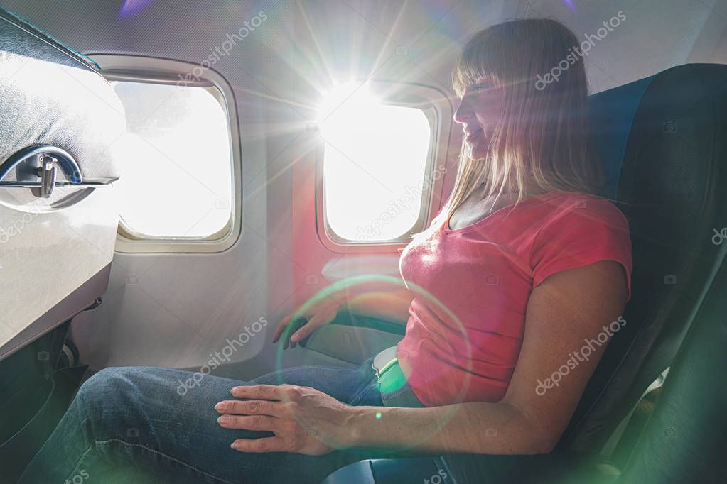 Happy woman in airplane.  Passenger sitting in aircraft.