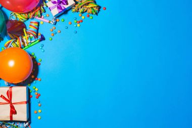 Mutlu yıllar ve tatil konsepti. Mavi arka planda hediye kutuları ve tatil aksesuarları. Kopyalama alanı olan üst görünüm.
