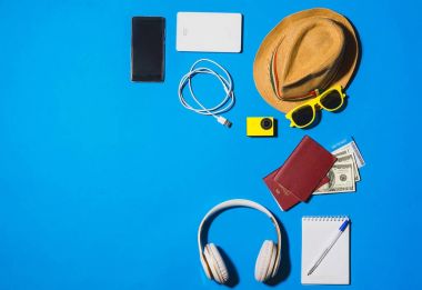 Random travel objects on blue background. Overhead view. clipart